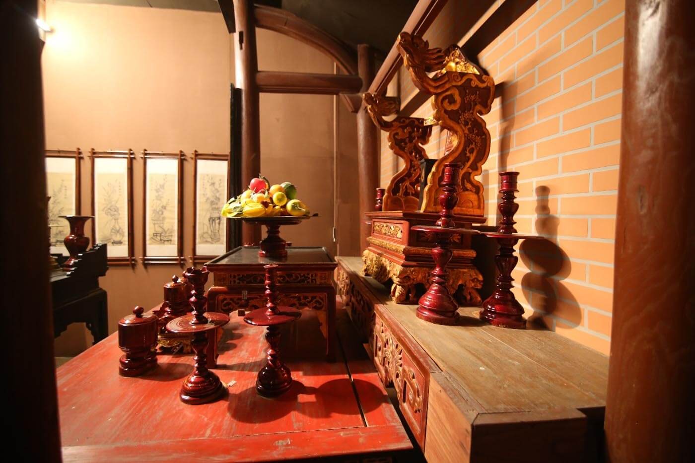 Bàn thờ gỗ chạm khắc tinh xảo với mâm trái cây, đặt trong không gian nội thất truyền thống.