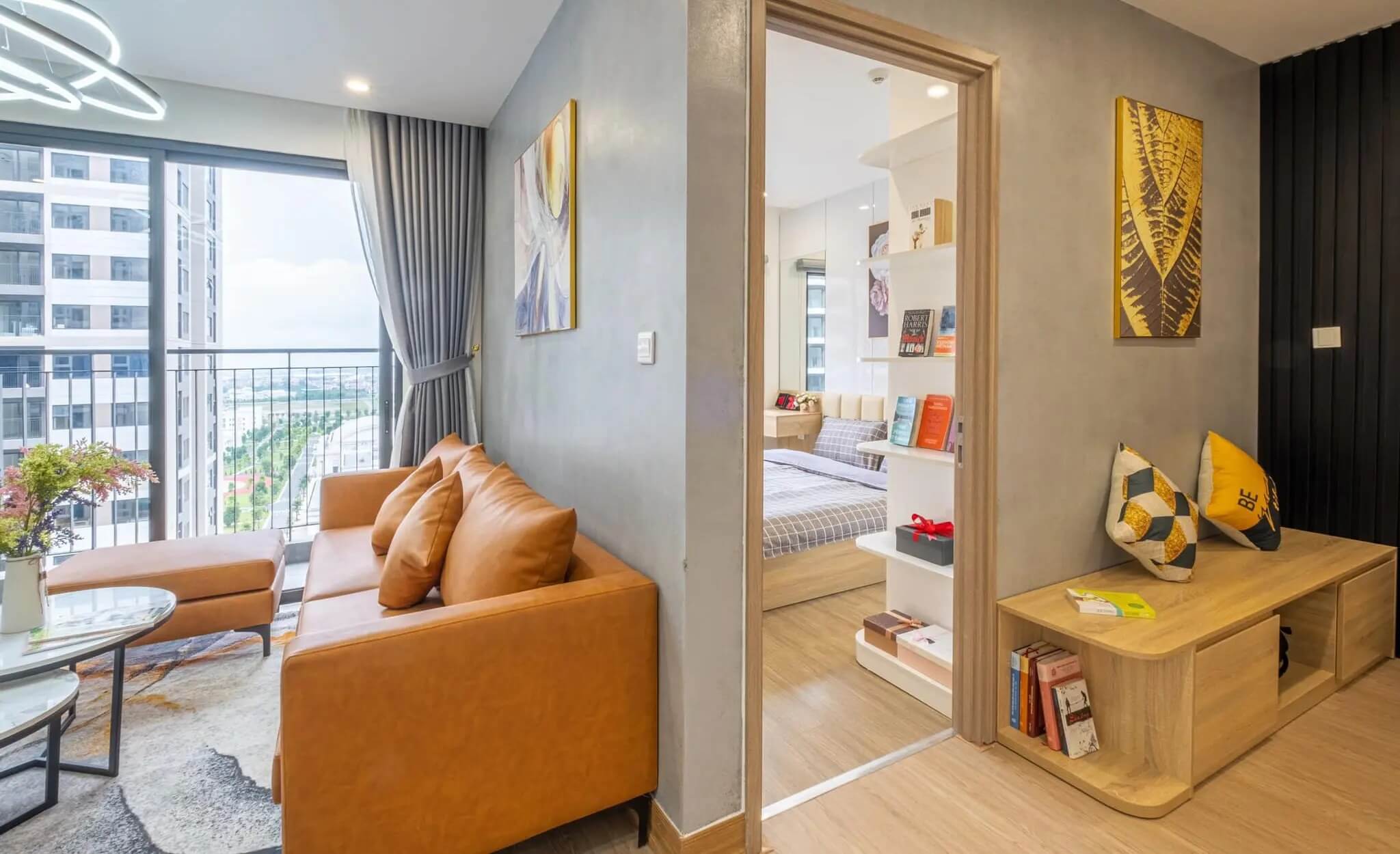 Căn hộ hiện đại với phòng khách, ghế sofa nâu và cửa kính lớn, ánh sáng tự nhiên tràn ngập.