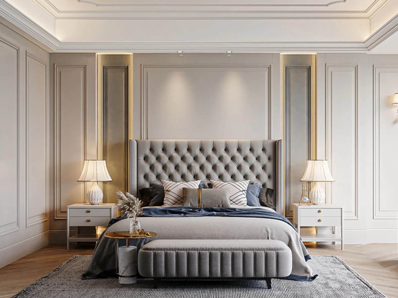 Phòng ngủ sang trọng với giường bọc nệm xám, đèn bàn cổ điển và tường trang trí tinh tế.