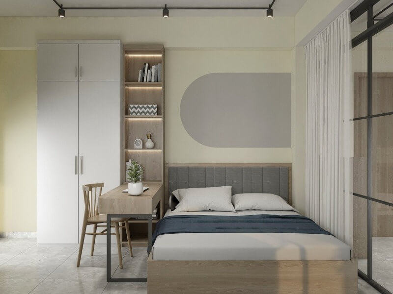 Phòng ngủ nhỏ hiện đại với giường, tủ quần áo, bàn làm việc và ánh sáng tự nhiên từ cửa sổ kính.