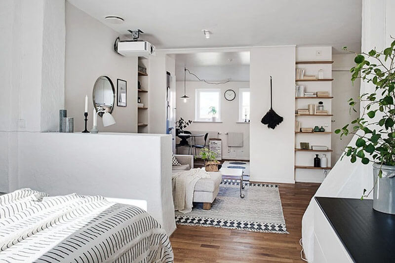 Phòng khách và ngủ phong cách Bắc Âu, nội thất trắng sáng, sàn gỗ, trang trí cây xanh.
