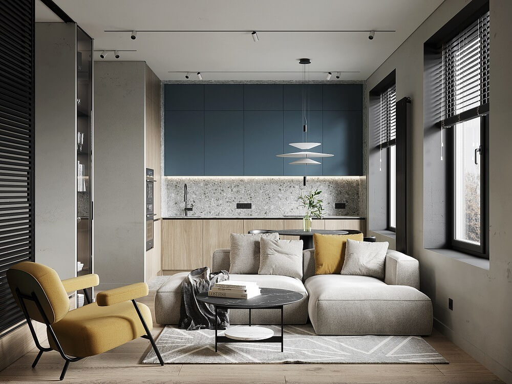 Phòng khách hiện đại với sofa xám, ghế vàng, bếp nhỏ gọn, thiết kế nội thất tối giản và ánh sáng tự nhiên.