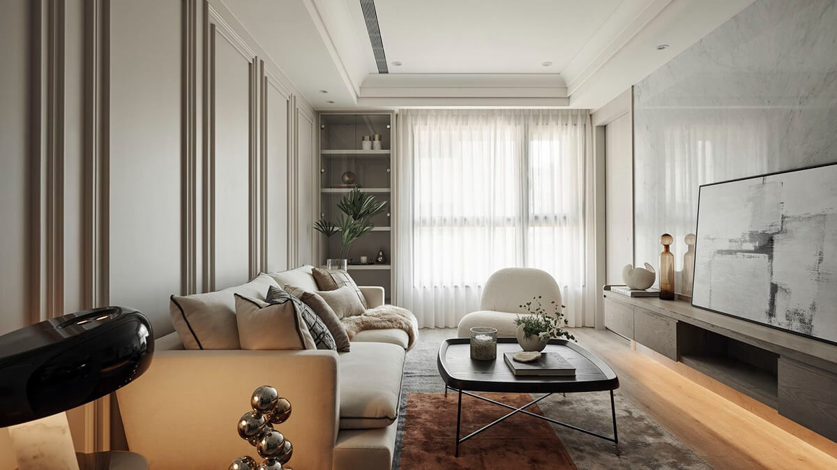 Phòng khách hiện đại với sofa màu xám, bàn cà phê và tranh treo tường tối giản, ánh sáng tự nhiên từ cửa sổ.