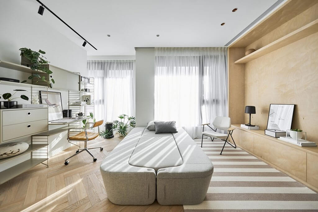 Phòng làm việc hiện đại với ánh sáng tự nhiên, cây xanh và nội thất tối giản.