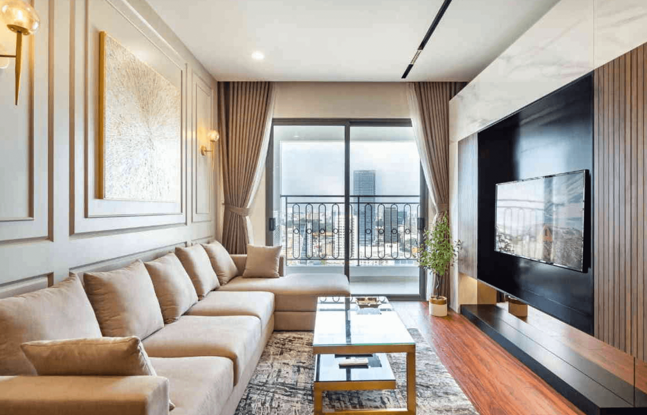 Phòng khách hiện đại với ghế sofa lớn, cửa sổ rộng và tivi treo tường, thiết kế tông màu nhẹ nhàng.