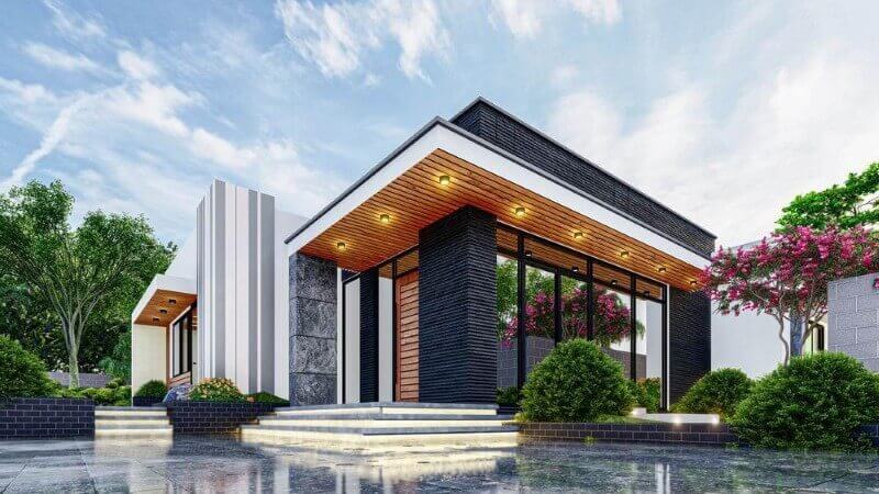 Nhà hiện đại một tầng với mặt tiền ốp gạch, cửa kính lớn, cây xanh và hoa xung quanh.