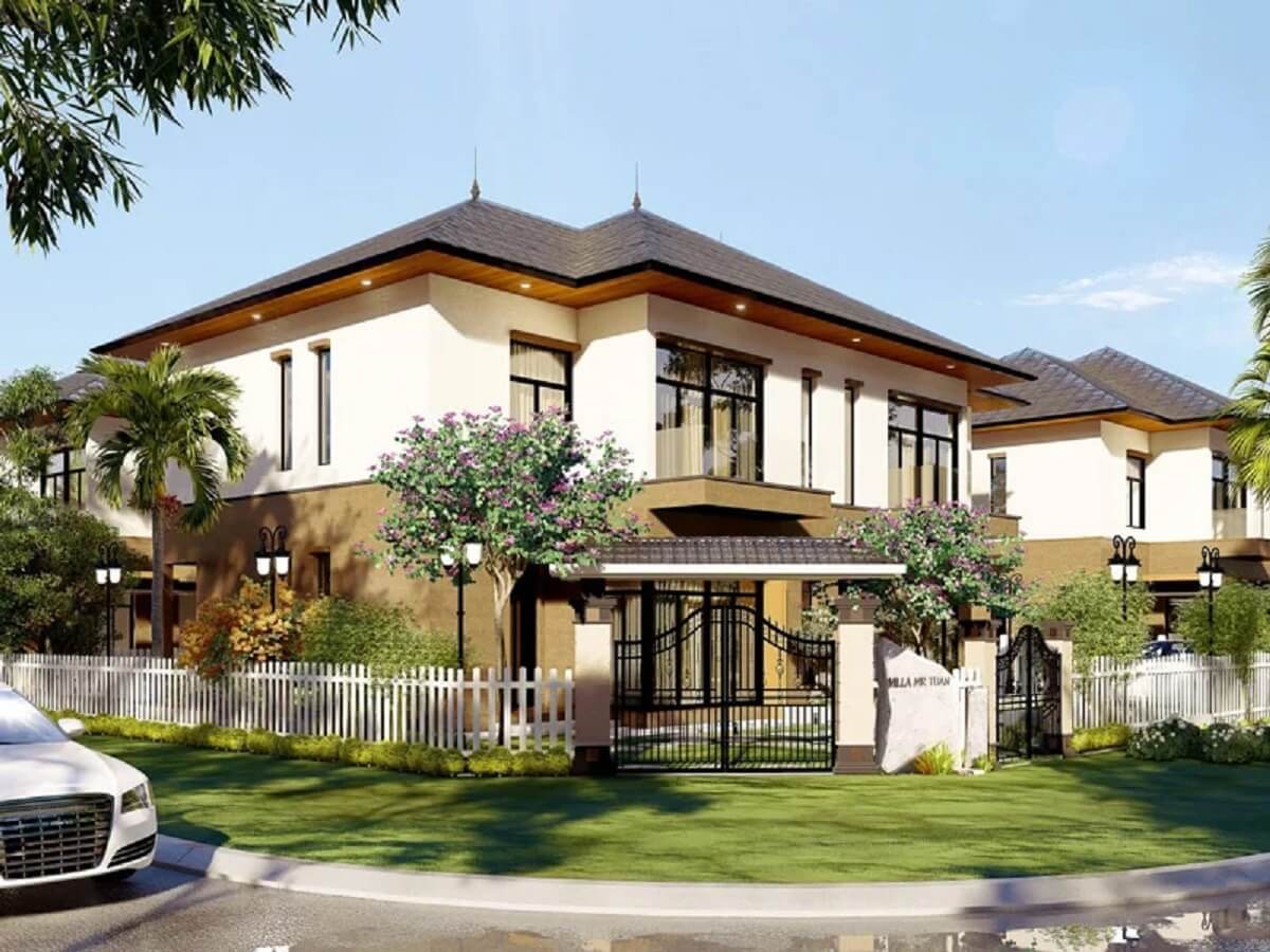 Biệt thự sang trọng với vườn cây xanh và hàng rào trắng, nằm cạnh đường phố yên tĩnh.