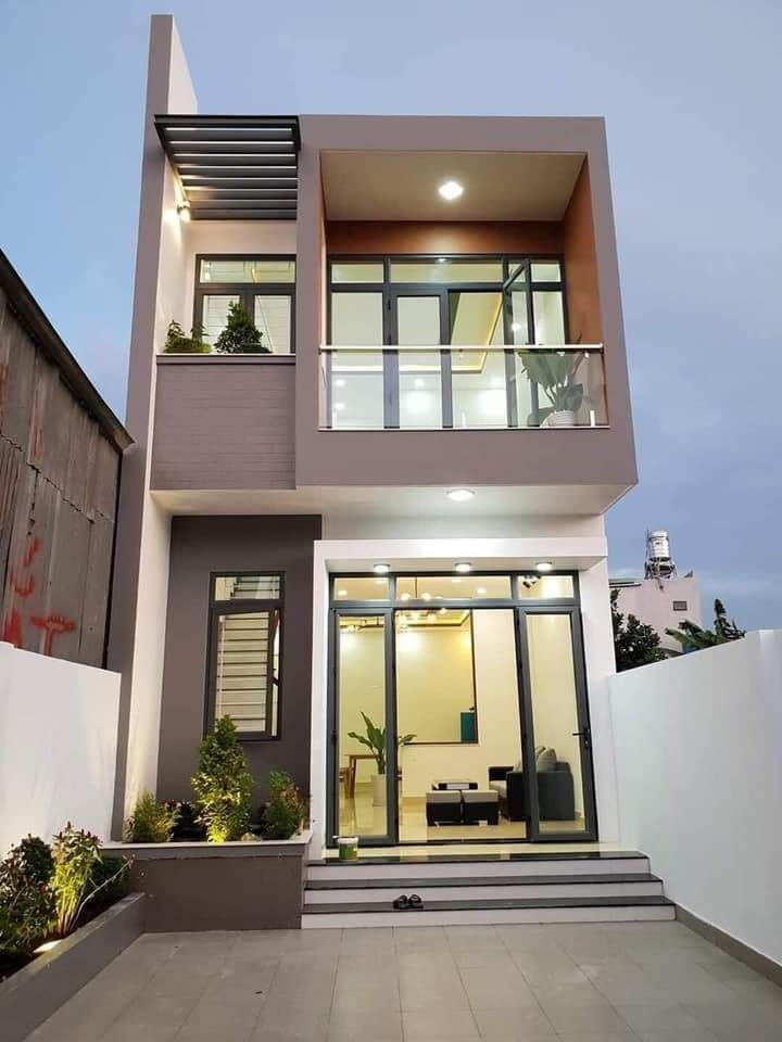 Nhà phố hiện đại hai tầng với kính lớn và ban công, phong cách tối giản, buổi tối, ánh sáng ấm áp.