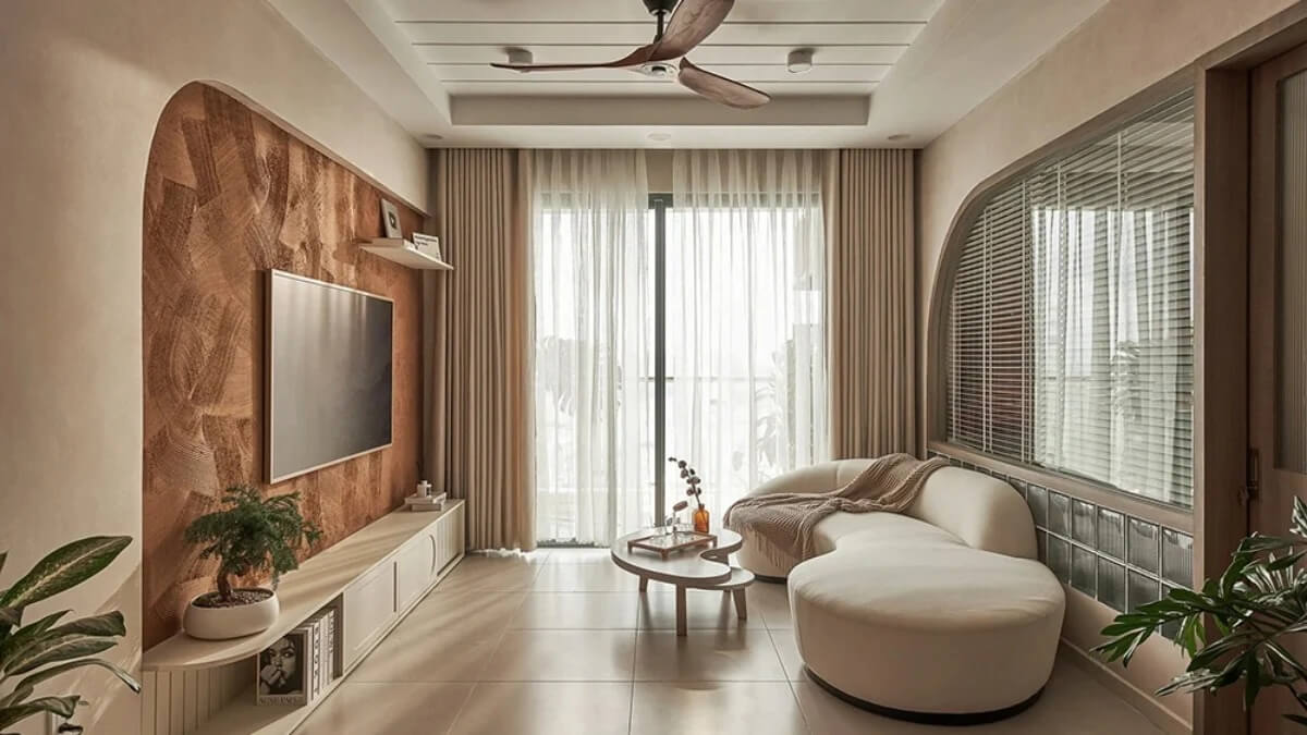 Phòng khách sang trọng với ghế sofa trắng, bàn trà gỗ và cây xanh, cửa sổ rộng thoáng sáng.