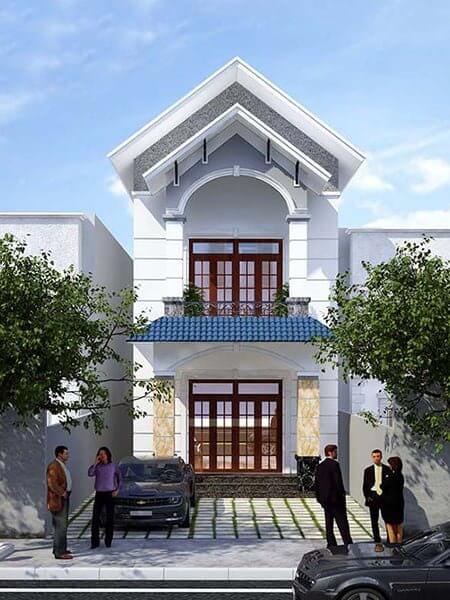 Mặt tiền nhà phố hiện đại hai tầng với mái ngói xanh, cây xanh xung quanh và vài người đứng trò chuyện phía trước.