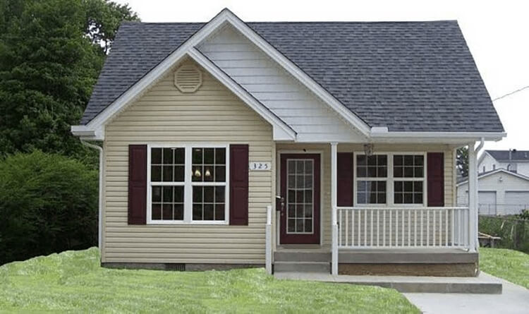 Ngôi nhà nhỏ với mái hiên, cửa sổ lớn và cỏ xanh bao quanh, mang phong cách kiến trúc ấm cúng.