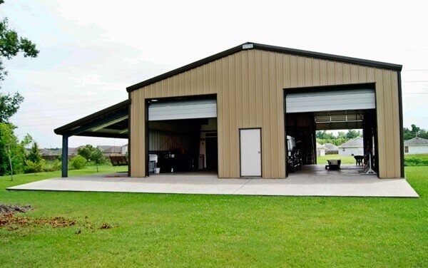 Tòa nhà kho lớn màu nâu với sân bê tông rộng, xung quanh có cỏ xanh, lý tưởng làm nhà xưởng hoặc lưu trữ.