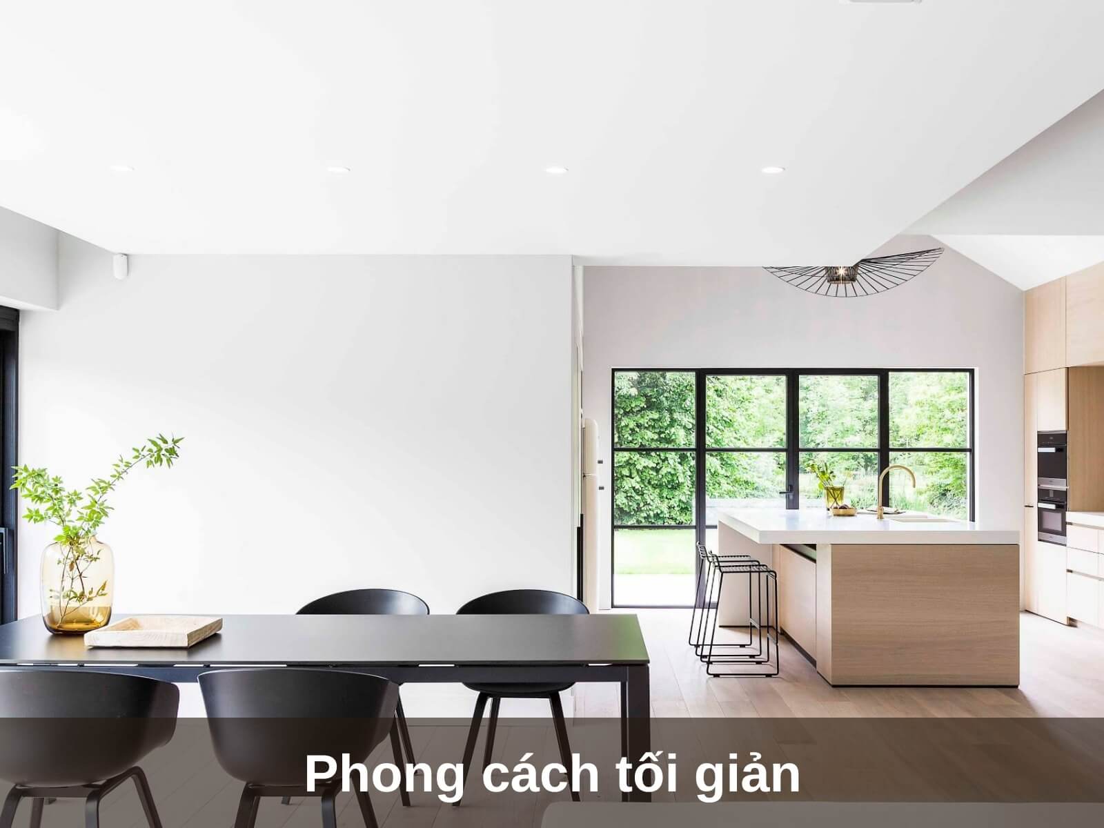 Nhà bếp hiện đại với thiết kế tối giản, bàn gỗ, ghế đen và cửa sổ lớn nhìn ra cảnh quan xanh tươi.