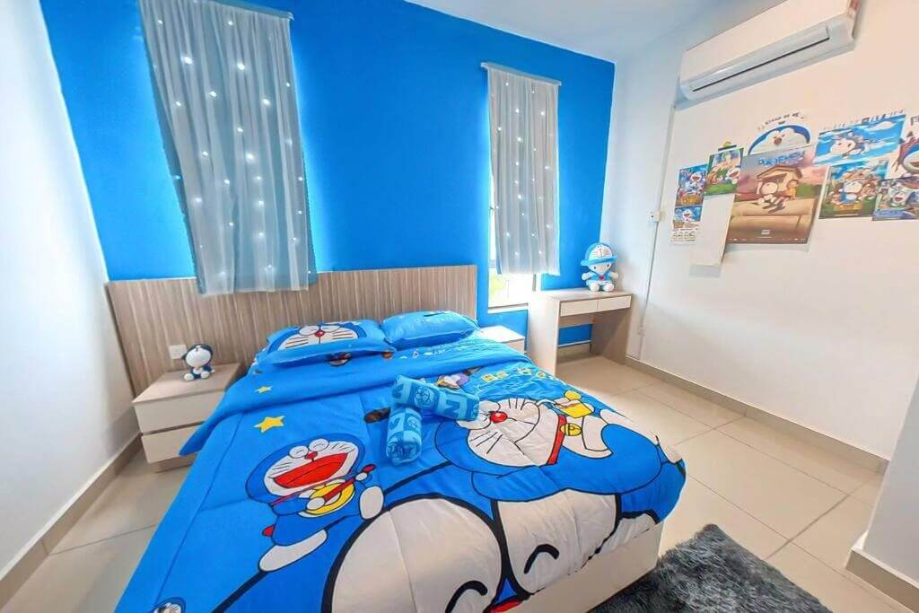 Phòng ngủ trang trí theo chủ đề hoạt hình với chăn gối và áp phích xanh dương tươi sáng.