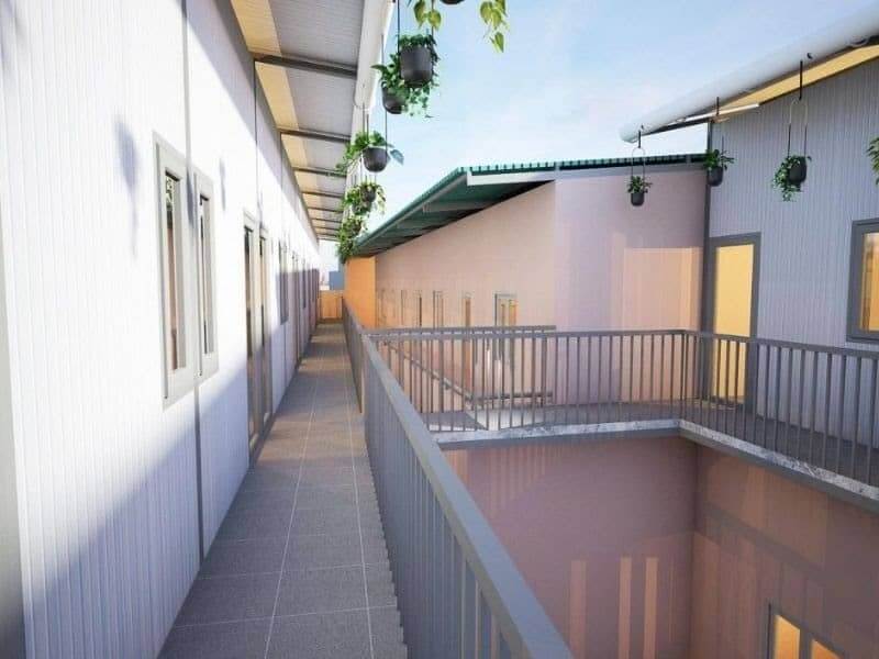 Hàng lang với lan can hiện đại và chậu cây xanh treo tạo không gian thân thiện và thoáng mát.