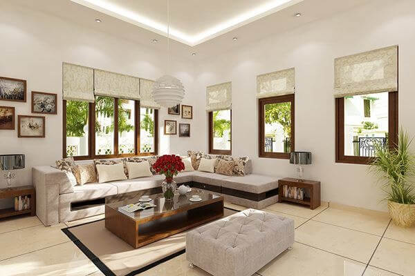 Phòng khách hiện đại với sofa trắng, bàn gỗ nâu, tranh treo tường và cây xanh, ánh sáng tự nhiên.
