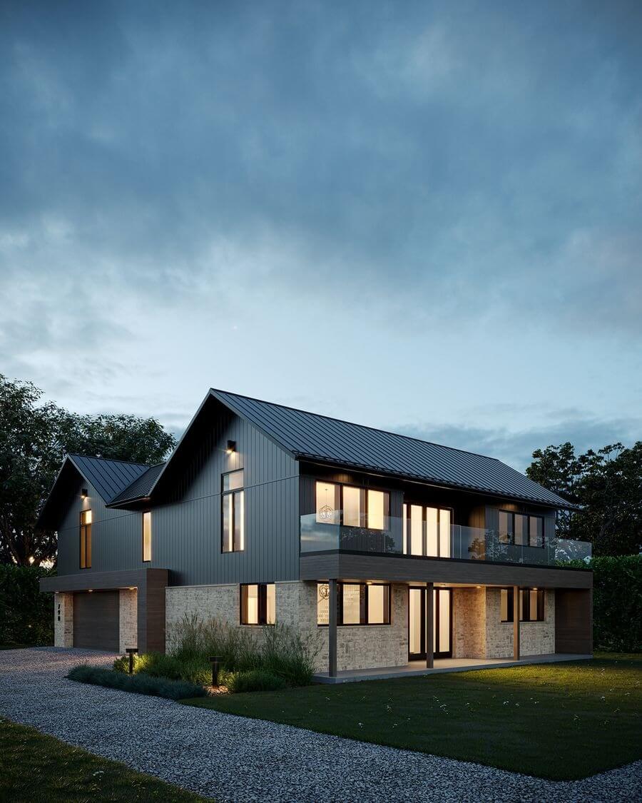 Nhà hiện đại buổi tối với ánh sáng, mái kim loại và cửa sổ lớn, xung quanh có cây cối và con đường sỏi.