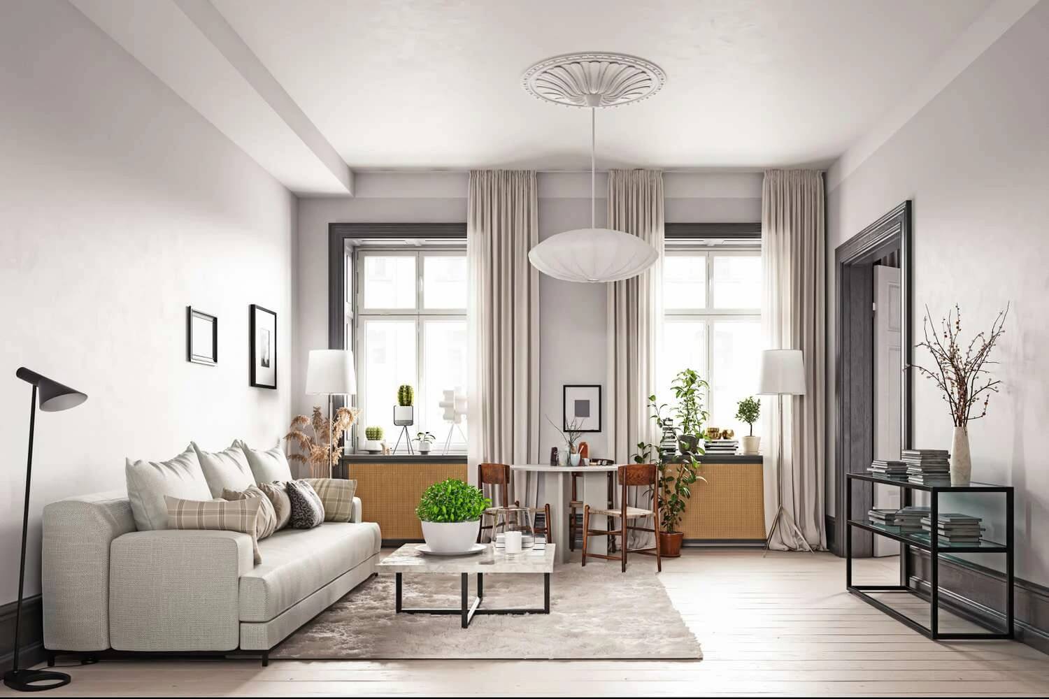 Phòng khách hiện đại với sofa trắng, bàn cà phê, cây xanh và ánh sáng tự nhiên từ cửa sổ lớn.