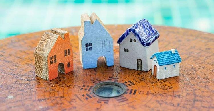 Mô hình nhà nhỏ đặt trên la bàn phong thủy, biểu thị sự hài hòa và cân bằng trong kiến trúc.