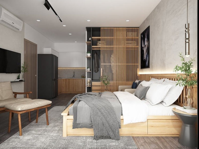 Phòng ngủ hiện đại, nội thất gỗ sáng màu, trang trí cây xanh, giường và ghế dựa thoải mái, liền bếp tiện nghi.