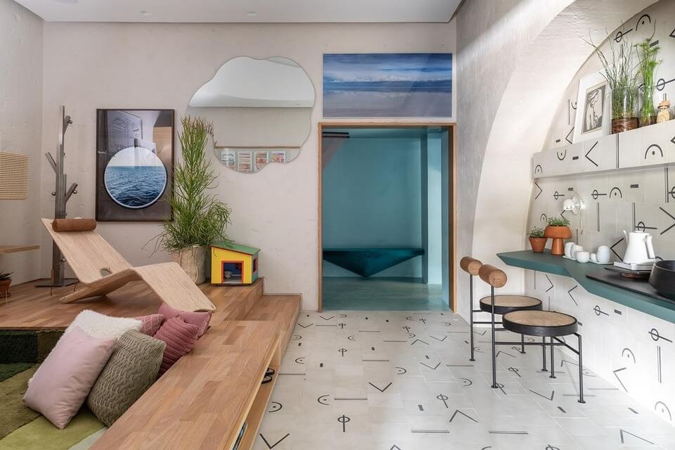 Phòng khách hiện đại với ghế sofa, bàn ghế, cây cảnh và tranh treo tường. Thiết kế nội thất sáng tạo và ấm cúng.