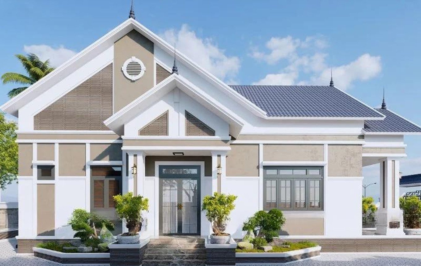 Ngôi nhà cấp 4 mái thái màu trắng, sân vườn trang trí cây xanh, nền trời xanh.