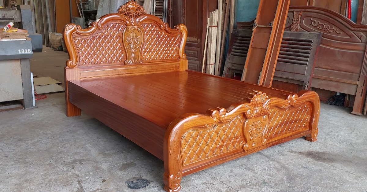 Giường gỗ chạm khắc tinh xảo trong xưởng, sang trọng và phong cách cho nội thất phòng ngủ.