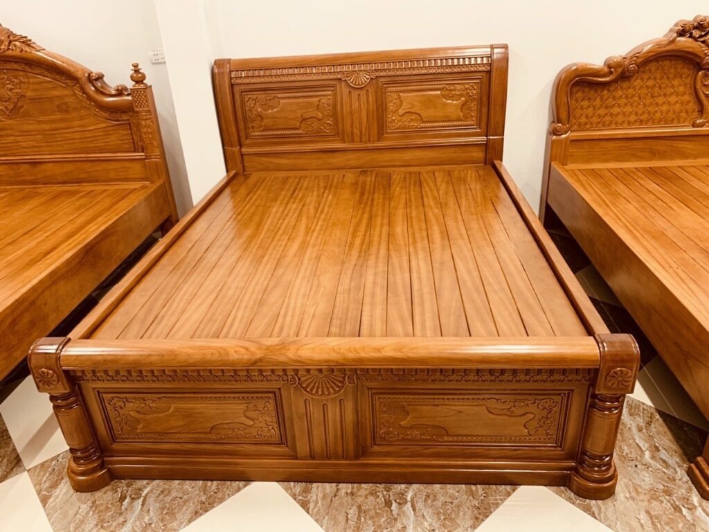 Giường gỗ tự nhiên chạm khắc tinh xảo, màu nâu đậm, đặt trong phòng ngủ sáng sủa.