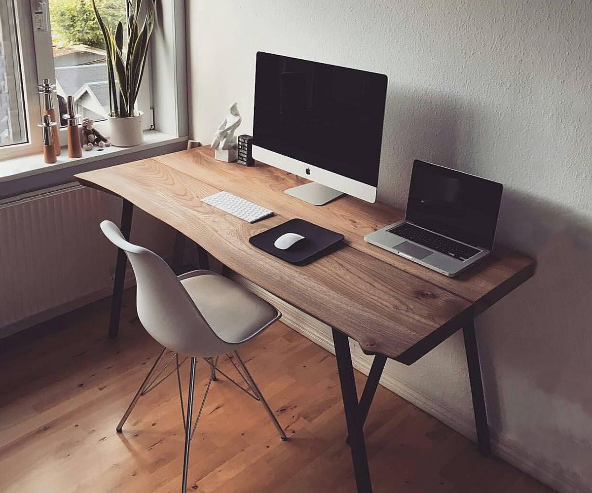 Góc làm việc hiện đại với máy tính bàn và laptop trên bàn gỗ cạnh cửa sổ, thiết kế tối giản.