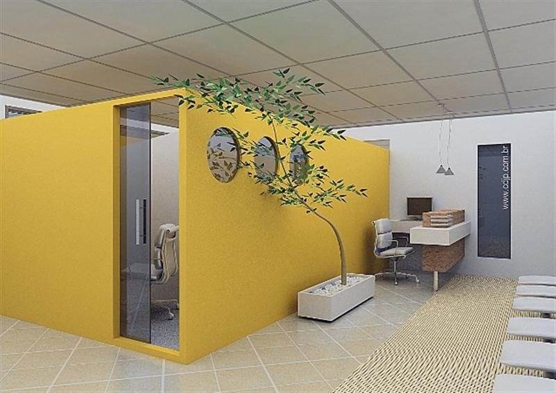 Phòng làm việc hiện đại với vách ngăn vàng và cây xanh, bàn làm việc có máy tính và ghế văn phòng.