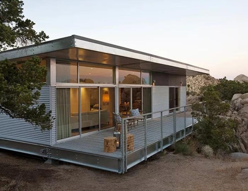 Ngôi nhà hiện đại với cửa kính lớn và ban công rộng, nằm giữa thiên nhiên hoang dã yên bình.