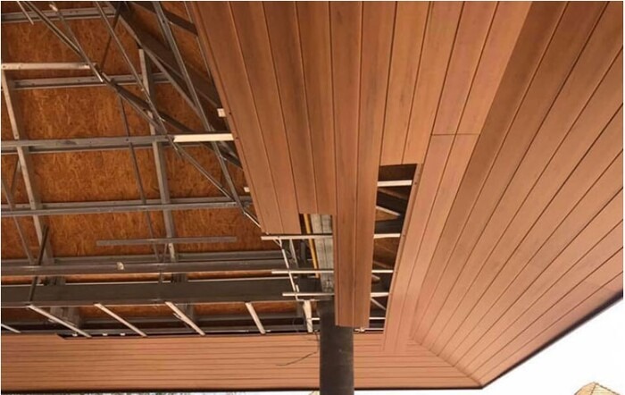 Thi công trần nhựa giả gỗ trong nhà, khung xương kim loại lộ, mẫu thiết kế hiện đại, tiết kiệm không gian.
