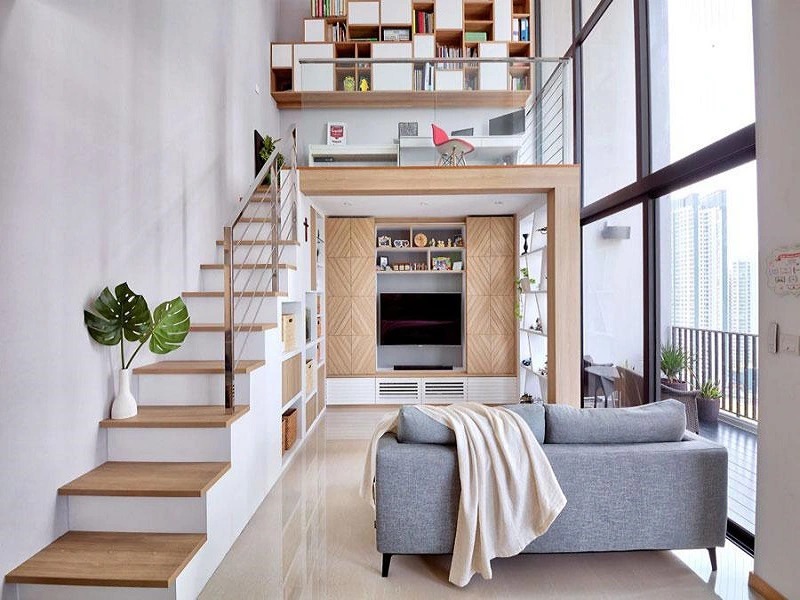 Căn hộ nhỏ với thiết kế gác xép hiện đại, nội thất tối giản, cầu thang gỗ, và phòng khách với sofa màu xám.