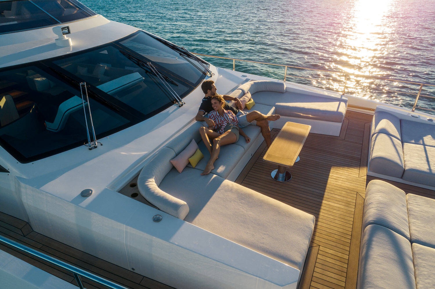 Cặp đôi thư giãn trên du thuyền, tận hưởng hoàng hôn tuyệt đẹp trên biển.