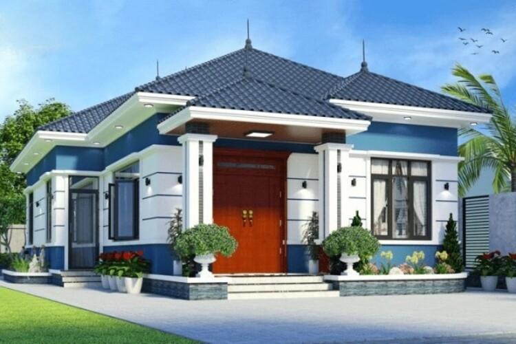 Ngôi nhà hiện đại, mái thái xanh, tường trắng và xanh biếc, sân vườn nhỏ, cây cối xung quanh, bầu trời trong xanh.