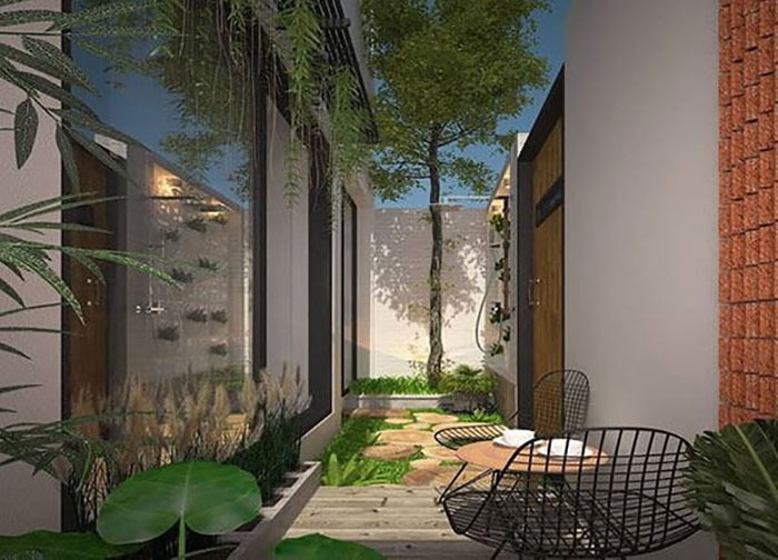 Sân vườn nhỏ với lối đi lát đá, bàn ghế ngoài trời và cây xanh tạo không gian thư giãn gần gũi với thiên nhiên.