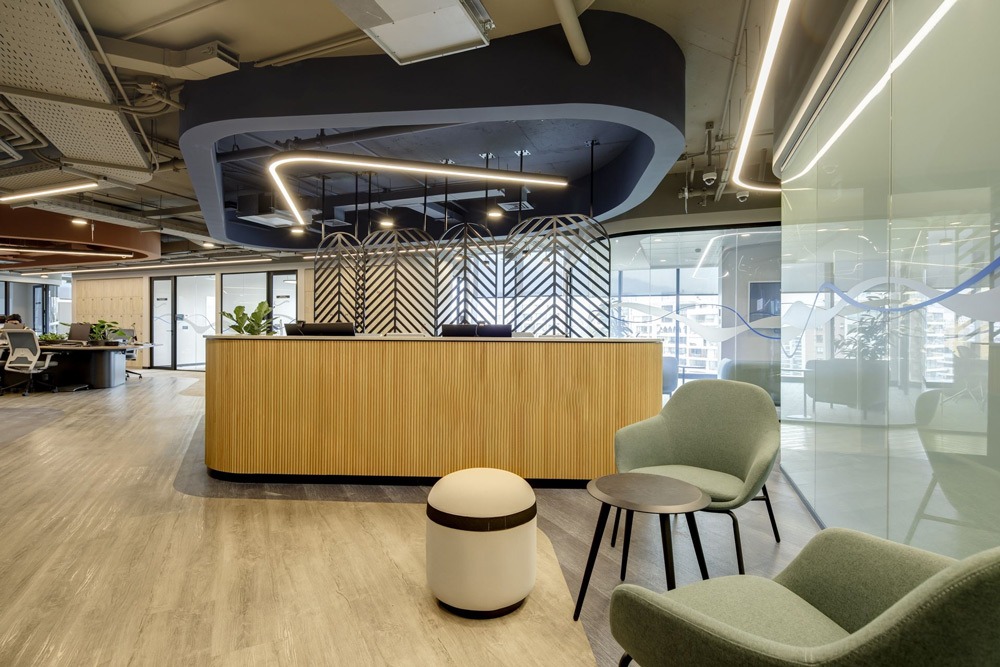 Không gian làm việc hiện đại với bàn tiếp tân gỗ, ghế sofa thoải mái và thiết kế ánh sáng độc đáo.