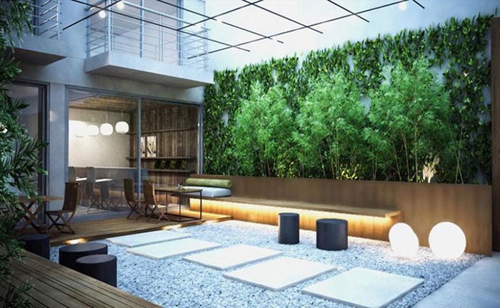 Sân vườn hiện đại với ghế dài, cây xanh, và ánh sáng dịu. Phong cách tối giản, tạo cảm giác thư giãn và thoải mái.