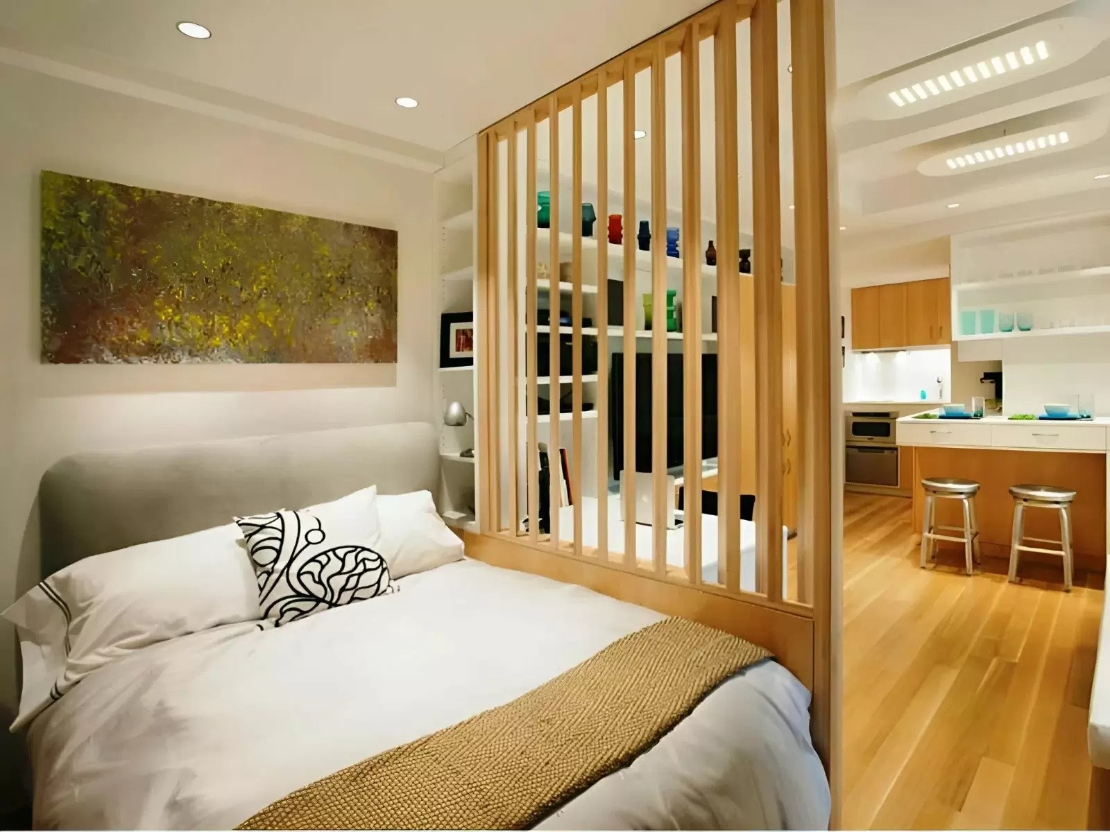 Phòng ngủ hiện đại với tường tranh nghệ thuật, nệm trắng, và ngăn phòng gỗ, liên thông khu bếp tiện nghi.