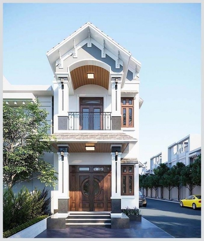 Nhà phố 2 tầng hiện đại với cửa gỗ và ban công, nổi bật trên nền trời xanh trong.