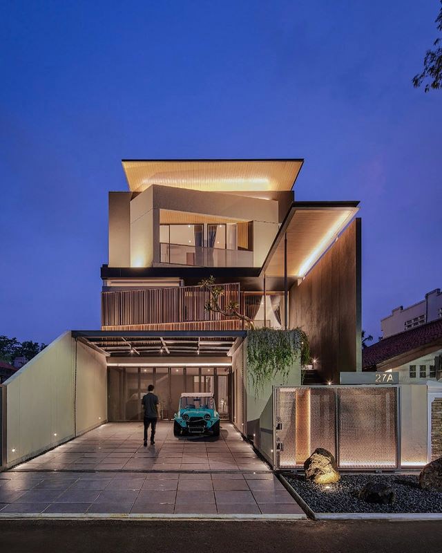 Ngôi nhà hiện đại với ánh sáng buổi tối, ô tô đậu phía trước, thiết kế kiến trúc đương đại.