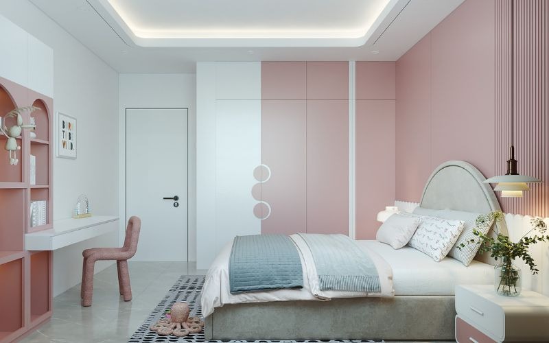 Phòng ngủ hiện đại với tường màu hồng, giường lớn và bàn làm việc, tạo không gian ấm cúng và thanh lịch.