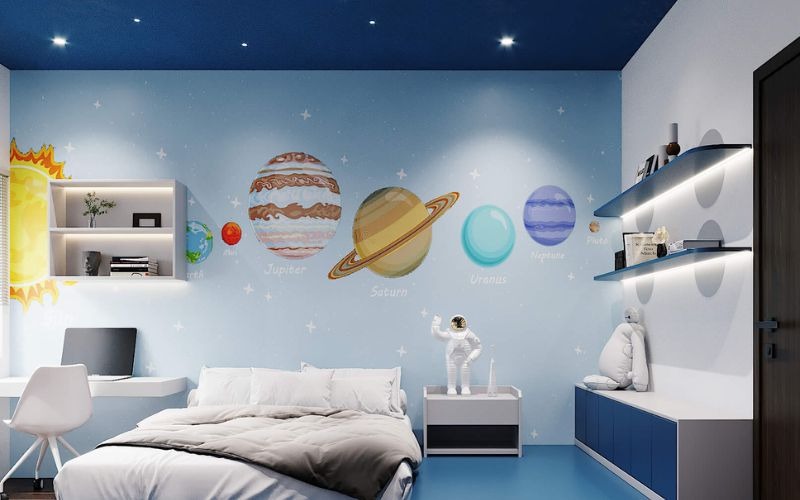 Phòng trẻ em trang trí hệ mặt trời, giường trắng, bàn học, và kệ sách hiện đại.