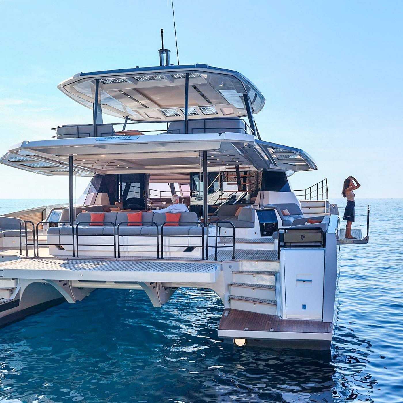 Du thuyền hiện đại trên biển xanh với người đứng ngắm cảnh, tạo cảm giác thư giãn sang trọng.