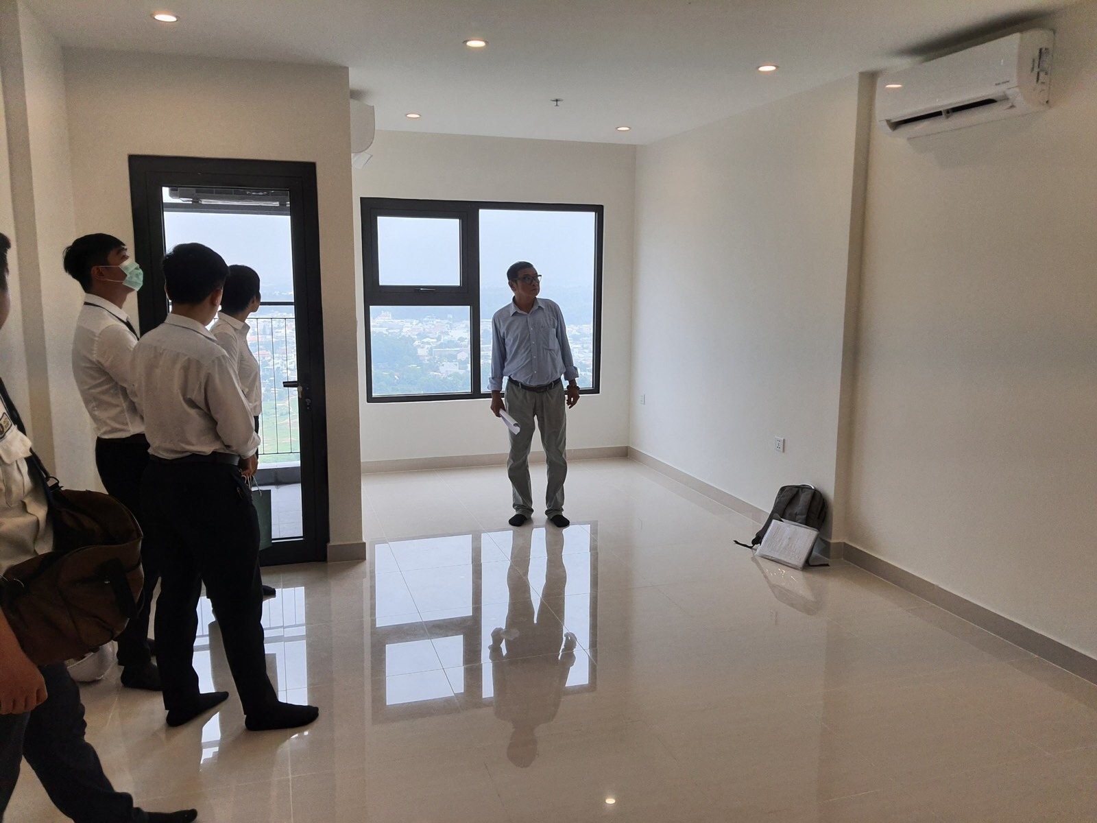 Nhân viên bất động sản giới thiệu căn hộ trống cho nhóm khách tham quan. Viễn cảnh từ cửa sổ căn hộ.