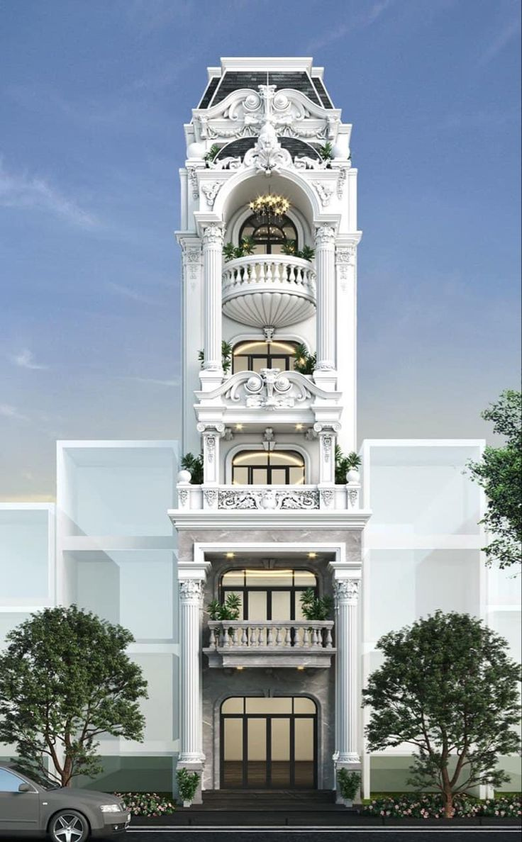 Tòa nhà tân cổ điển 5 tầng trắng, cửa vòm và cột trang trí, bầu trời xanh làm nền, cây xanh hai bên lối vào.