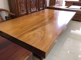 Bàn gỗ lớn với vân gỗ tự nhiên trong phòng, tạo không gian sang trọng và ấm cúng.