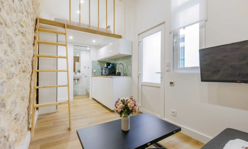 Căn hộ nhỏ, hiện đại với giường gác xếp, nhà bếp tiện nghi màu trắng và bàn hoa trang trí lãng mạn.