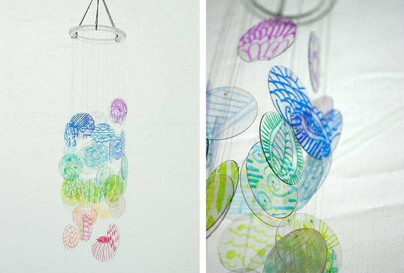 Chuông gió tự làm từ đĩa nhựa trong suốt màu sắc, treo trên dây trắng, tạo hiệu ứng nghệ thuật độc đáo.