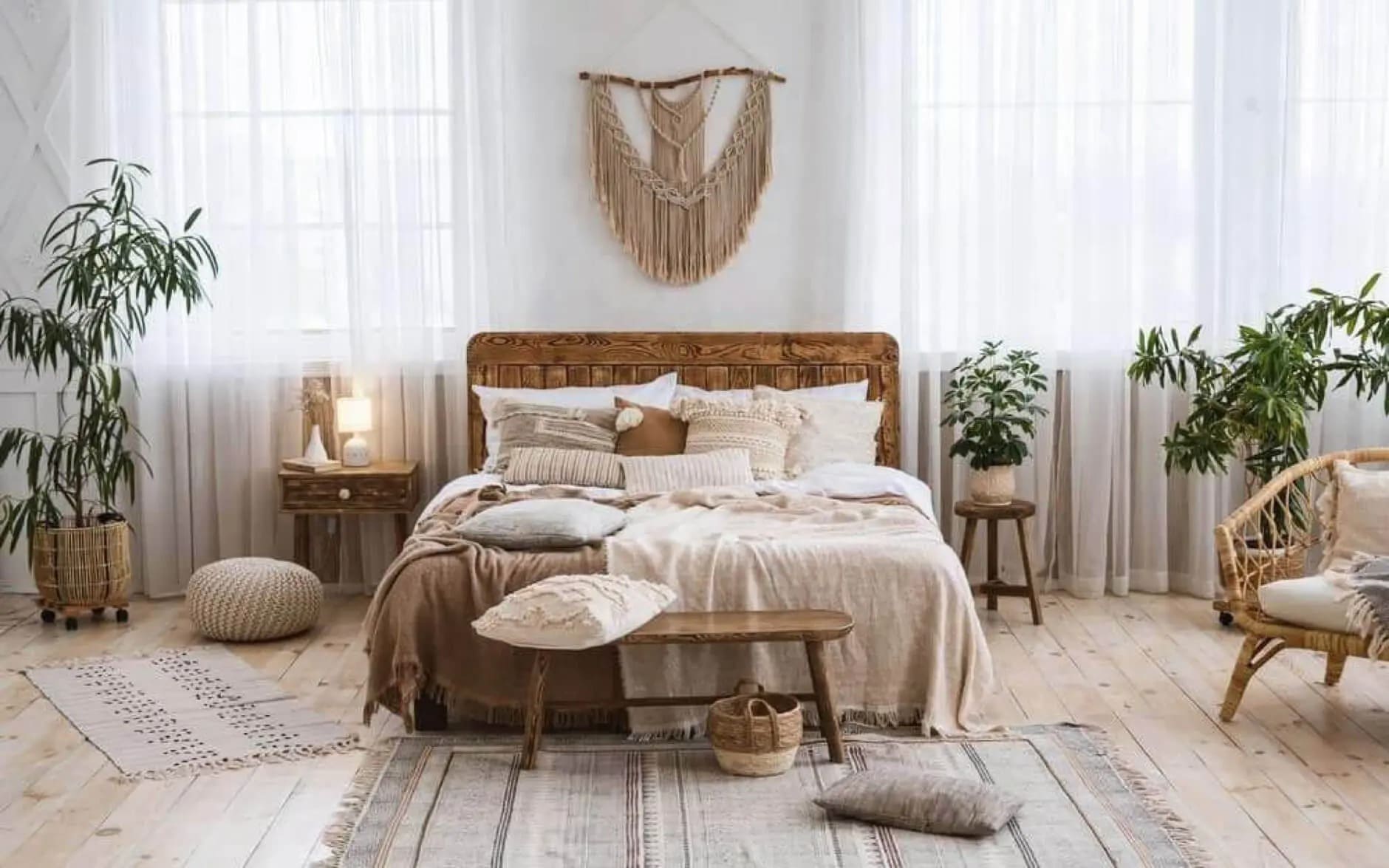 Phòng ngủ bohemian với giường gỗ, cây xanh, ánh sáng tự nhiên và đồ nội thất tông màu ấm áp.